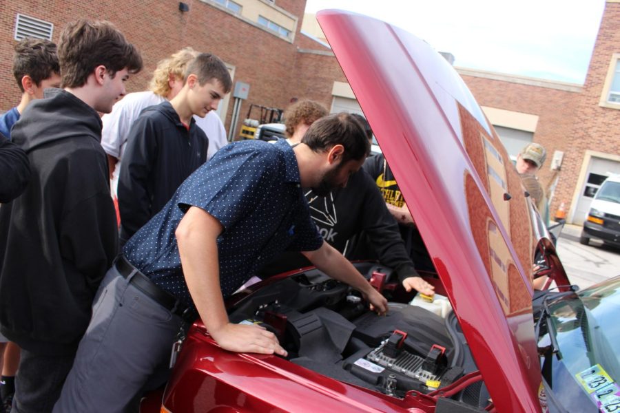 Adviser+Tyler+Martin+shows+students+what+to+look+for+when+checking+the+oil+in+his+red+Jeep.+%0APhotograph+by+Richard+Harper