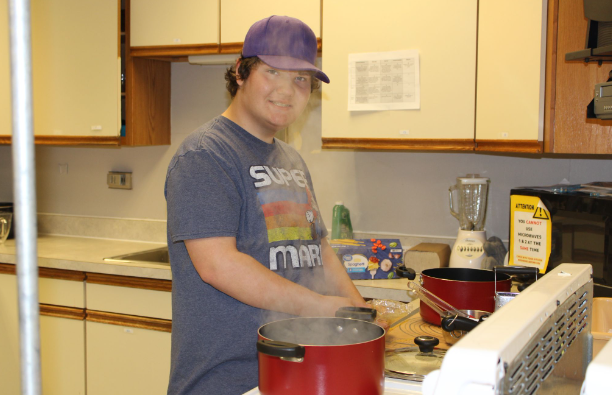 (grade level , name) is seen in the foods room happily boiling some noodles for his project.