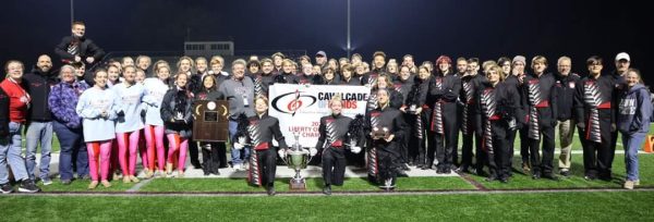 The marching band poses with their trophy after winning their third-straight Cavalcade of Bands championship. Photograph Courtesy of Chris Poole