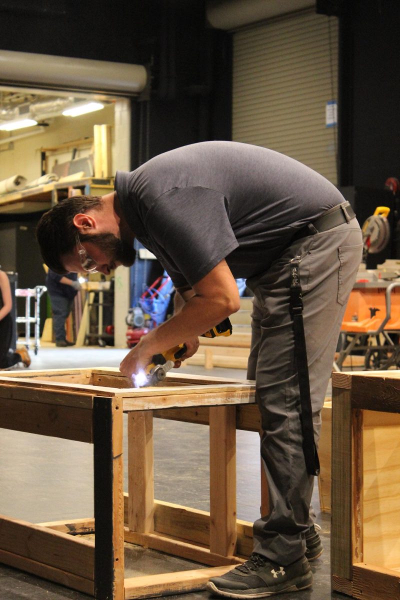 Teacher Tyler Martin works to construct set pieces for the upcoming play Lost Girl.