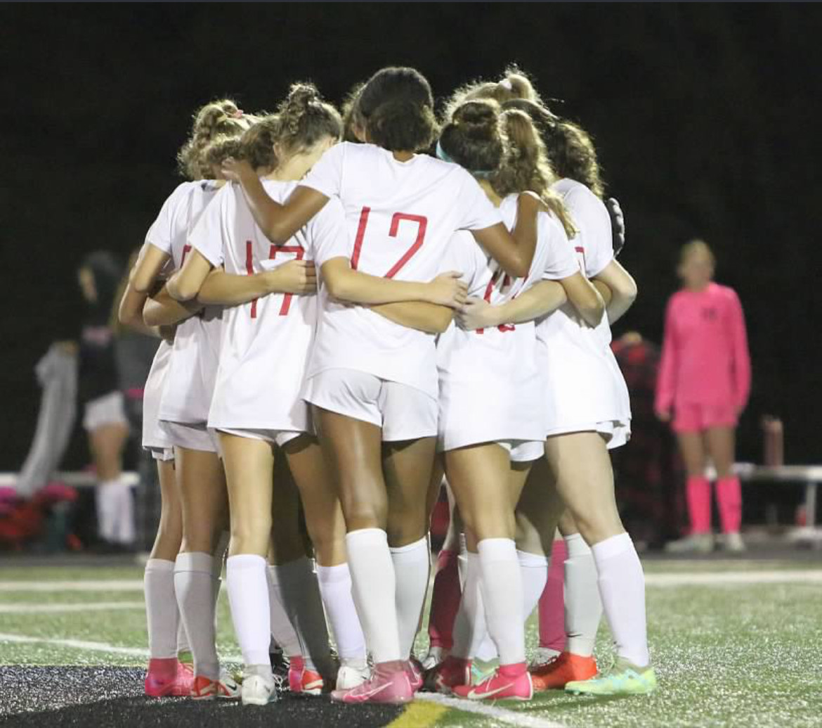 Girls soccer players show support for one another in a team huddle. Photograph  Courtesy of Julia Saidel