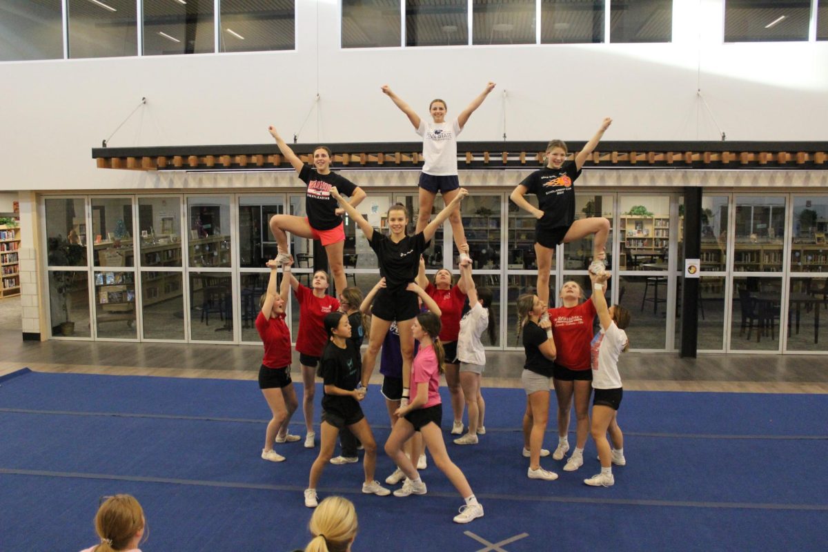 The cheer team perfects their pyramid at a practice in mid-December. The group has learned a method of conflict resolution that works for them. ¨The past few months we arent pointing fingers; we are giving advice, Clapsadl said. So rather than pointing fingers and saying this happened because of this person, we have been giving advice as maybe this would work better if we did this.¨ Photograph by Natalie Womack  