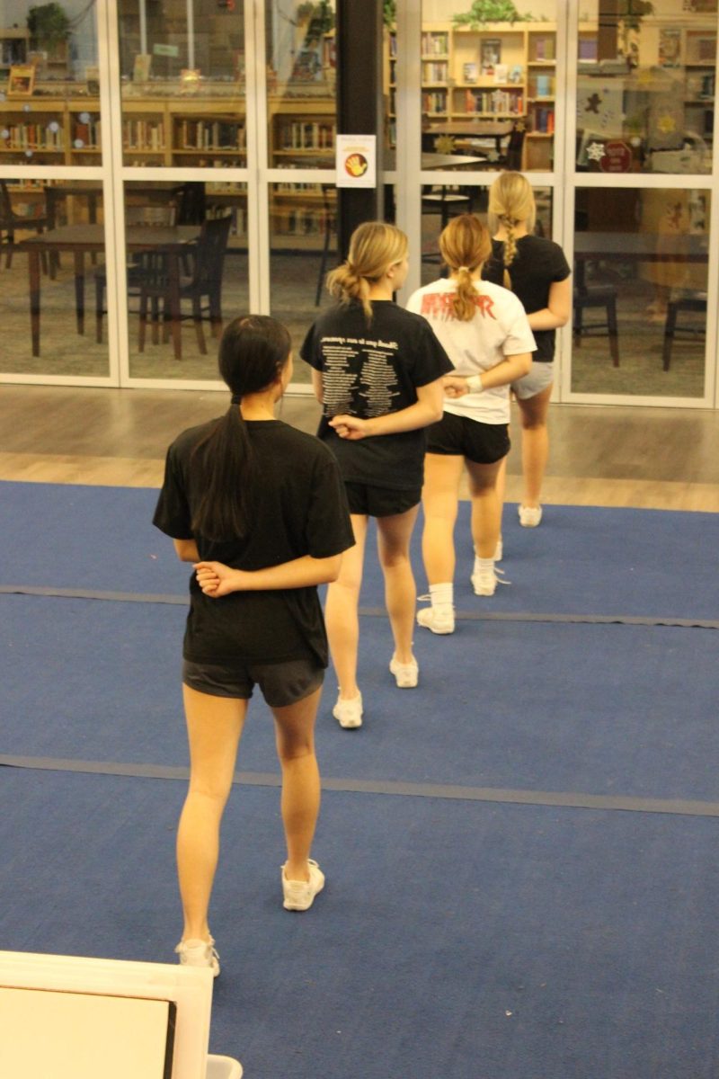 Sophomore Jenni Truong, junior Cassidy Derkosh, freshman Jocelyn Harper and freshman Autumn Miller wait eagerly in a line for the routine to start. The team has found ways to help calm their performance anxiety, according to freshman Peyton Frisch. Sometimes when you do a new skill or something that has not really been working in-front of many people it can be scary,¨ Frisch said. As long as you breathe, drink some water and try your best it will be ok. If it doesnt work out, you can always try again.¨ Photograph by Natalie Womack