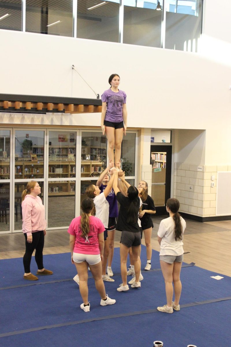 Freshman Peyton Frish, a Flyer, up in the air trusting her stunt group to keep her up. 