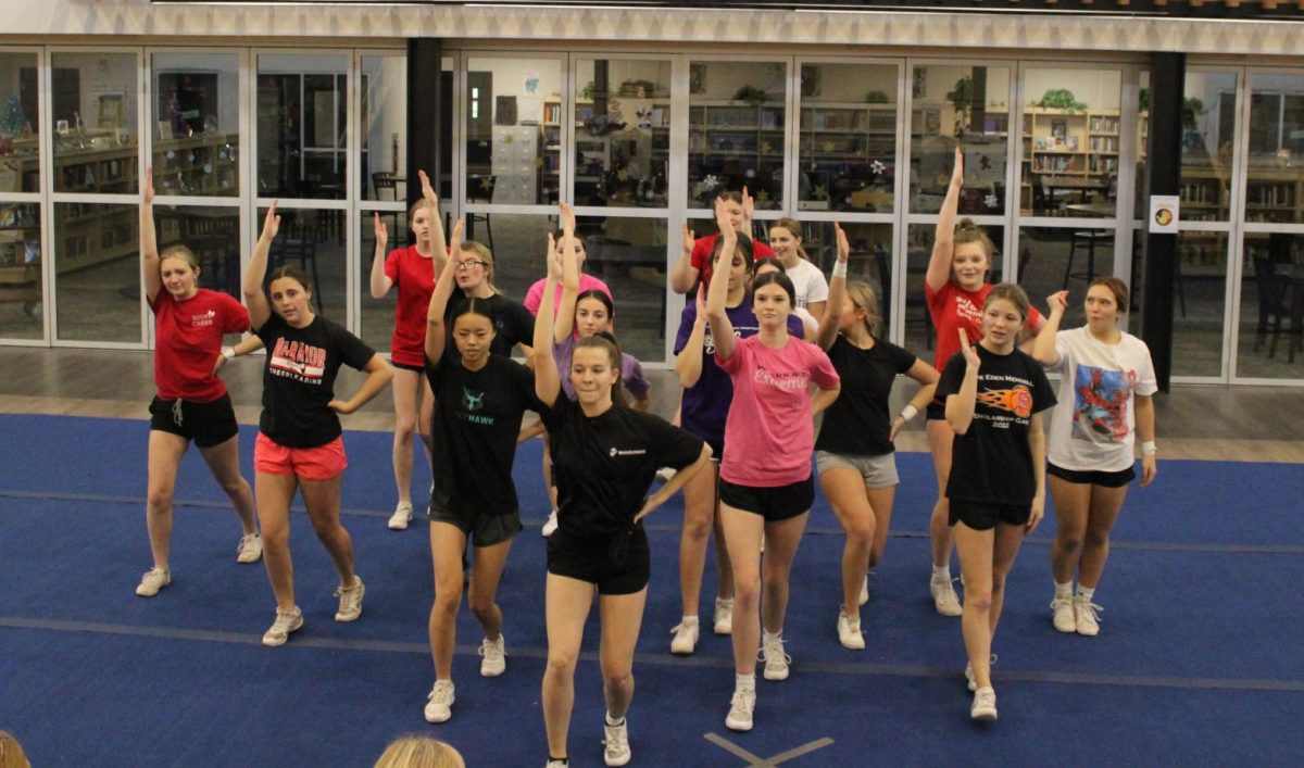 The entire cheer team practices their end-of-cheer stance. The winter season cheer squad includes three seniors, six juniors, three sophomores and six freshmen, according to the school districts website. Photograph by Natalie Womack