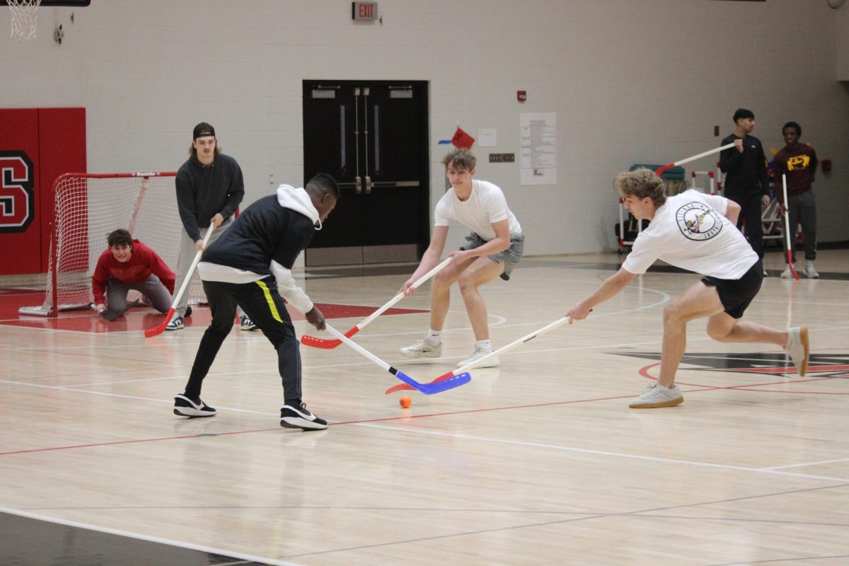 Two teams battle in floor hockey for the annual SHS Winter Olympics competition. Twelve different teams signed up to participate in this year’s floor hockey competition. The teams that signed up to compete in the Winter Olympics first competed in a preliminary round to see which two student teams will play in the final.  The final two teams competed during a pep rally on Dec. 22. The winning student team then got to play the teacher team at the pep rally. 
Photograph by Kendall Single
