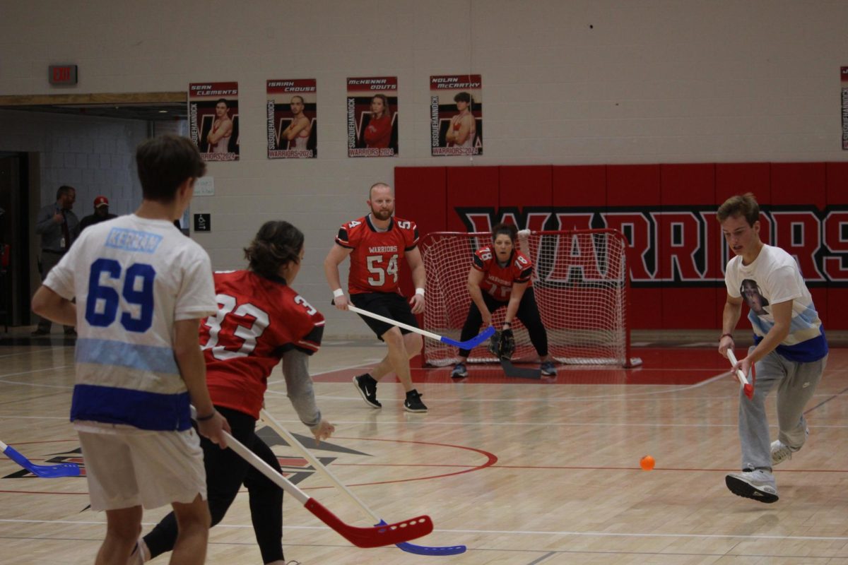 Senior Griffin Weeks makes a play on the ball during the final floor hockey game against the teachers at the pep rally on Dec. 22. The students beat the teachers 3-2 in the final. After the games were over, students left the gymnasium with hope and joy for a happy winter break. 
Student Council president Devin Gilbert is excited for next years event. “In the future we hope to have even more teams sign up for even more games. This year we had 12 teams for floor hockey and 1 team for dodgeball. In following years we hope to also have some additional games for people to play to make the event more exciting,” Gilbert said. 
Photograph by Kendall Single
