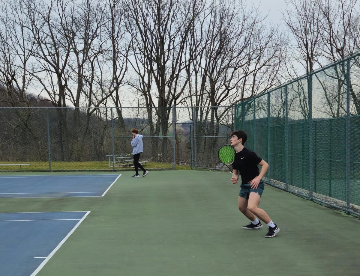 Senior Derek Baughman awaits a volley during a practice in early March. Photograph by Sienna Wanderer