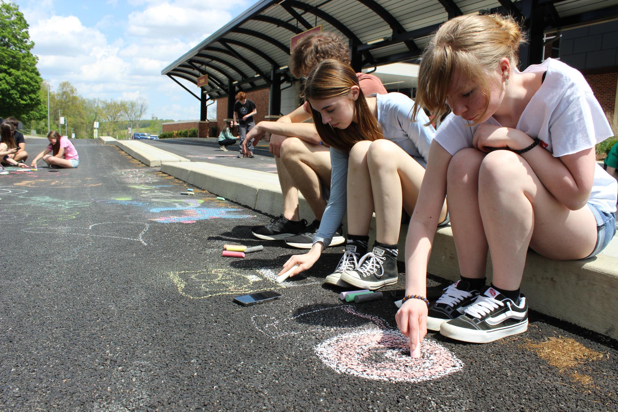  Juniors Sienna Wanderer and Samantha Streett coloring with chalk outside by the bus lane. Aevidum spent the month of April helping to educate students about the various activities to reduce stress and anxiety. Photograph by Kaden Richardson
