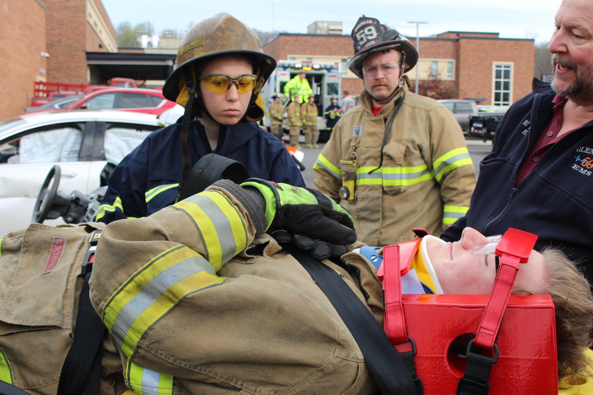 Students are guided by a professional on how to make sure victims are secure while being transported to safety. Neck supports, also known as cervical collars, are used on stretchers to immobilize the neck and head, preventing further injury and potentially protecting the spinal cord. photograph by Josie Witsik

