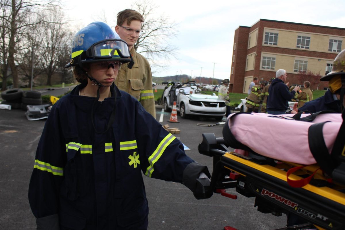   E.M.T. students assist moving a stretcher as part of their learning experience.  Multiple EMTs are needed when handling stretchers, especially for lifting and transferring patients, to ensure safety and proper ergonomics for both the patients and the EMTs. Photograph by Josie Witsik


