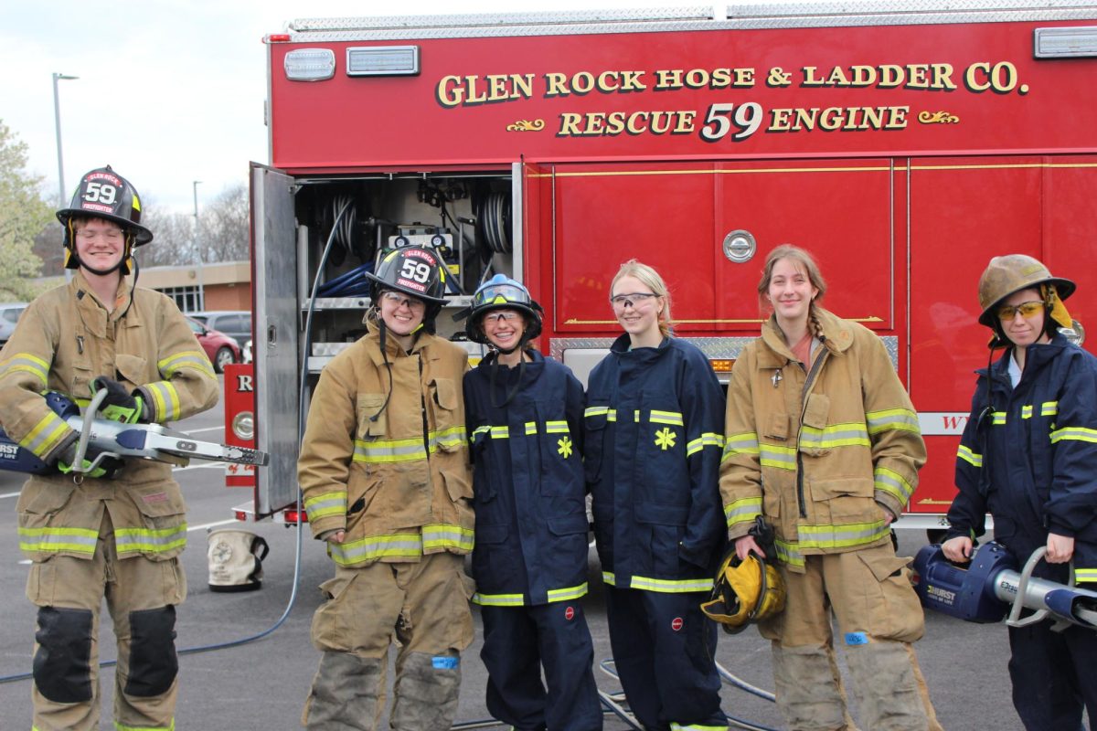 E.M.T. students and professional rescue workers stand in front of a Glen Rock rescue engine.  Being both a firefighter and an EMT is important because it allows for a single response team to handle both fire-related and medical emergencies. Photograph by Josie Witsik 
