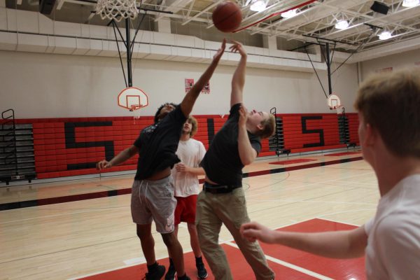 Sophomores Chandler Tindal and Sam Hall battle for a rebound while playing basketball during a physical education class in early May.  PE teachers say their classes create foundational habits for lifelong wellness, helping students understand how to maintain a balanced lifestyle through exercise, nutrition, and personal fitness goals. Photograph by Kelson Richardson