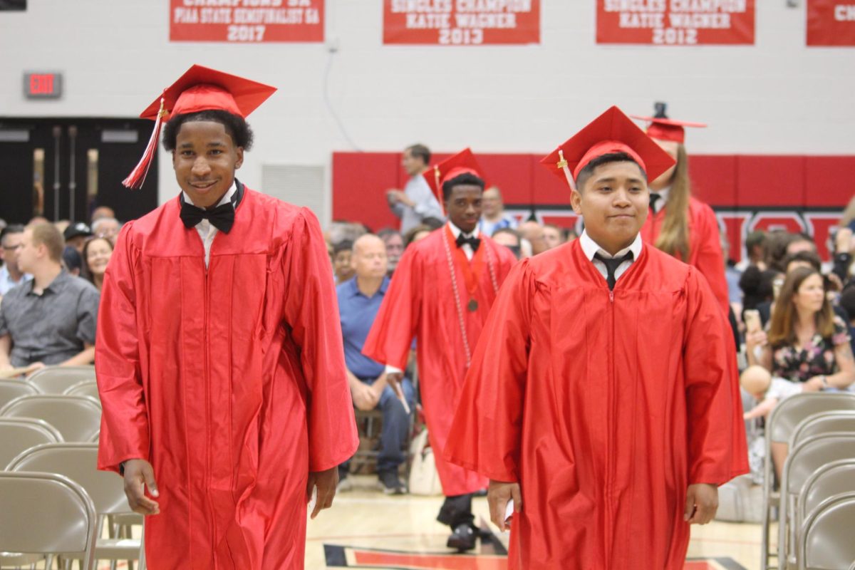 Seniors Jordan Brown and Nelson Avalos Amador walk towards their seats to prepare for the beginning of the 2025 Graduation Ceremony.  Photograph by Kendall Woods 