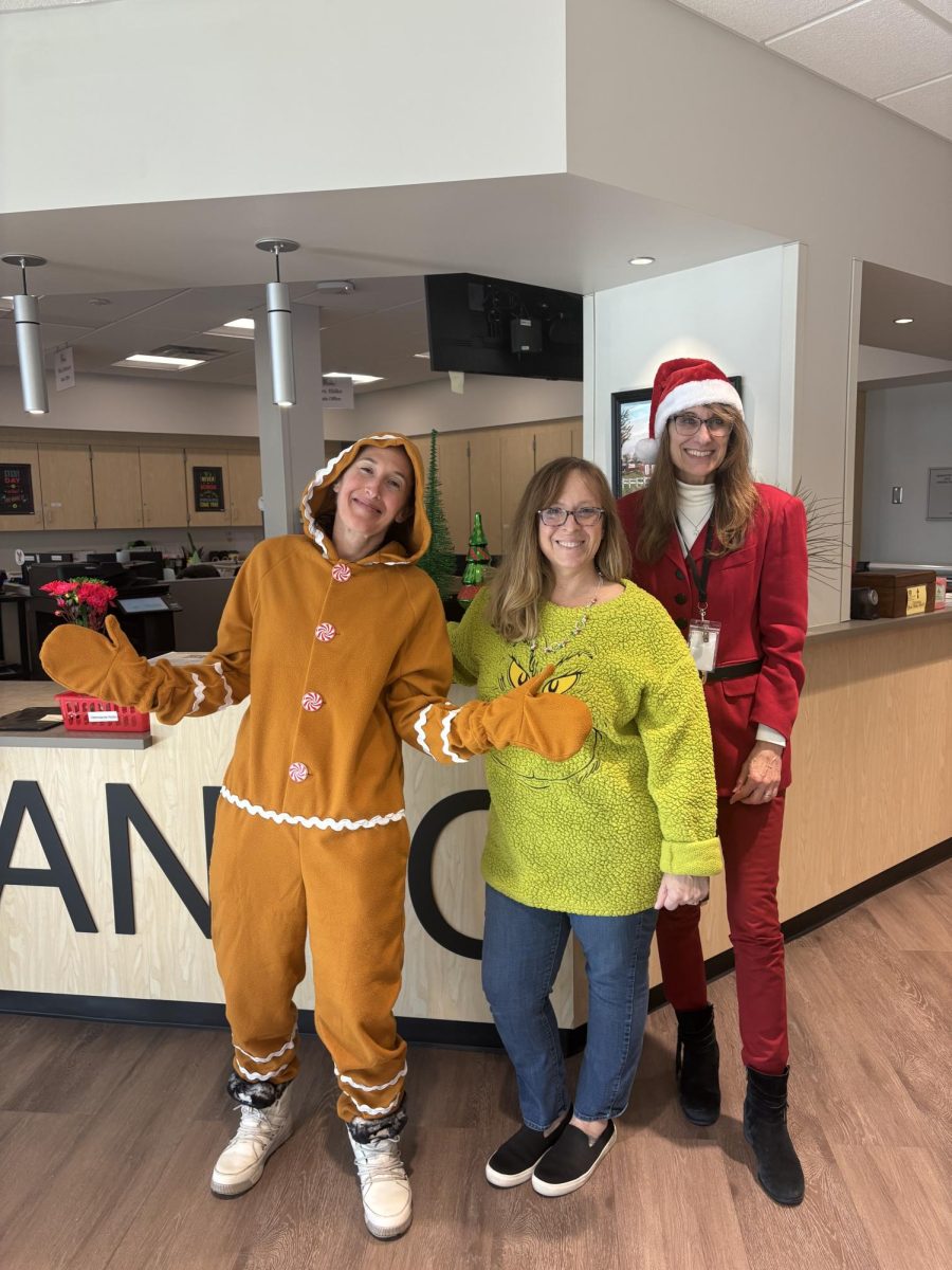 Main office assistants Kristy Ehlke, Julie Delozier and Natalie Hynoski go all out to greet visitors and students on ‘Winter Character Day.’ Many staff members participate in the spirit week because it’s a chance to wear more relaxed clothing. Photograph by Caroline Simpson