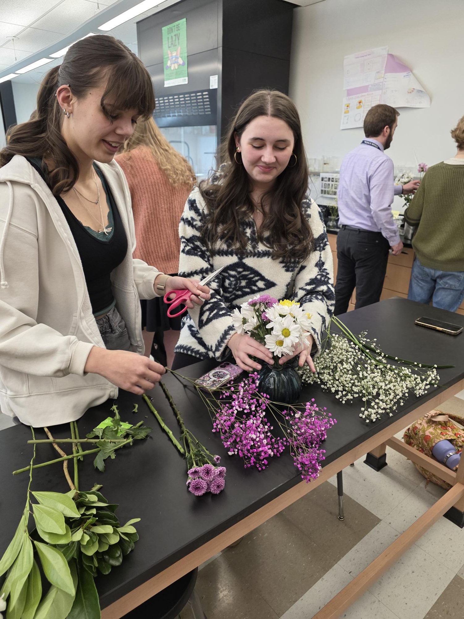 Juniors Joy Manning and Kaitlyn Staub arrange flowers to give to staff for their bouquets of thanks project. Photograph by Amanda Burris