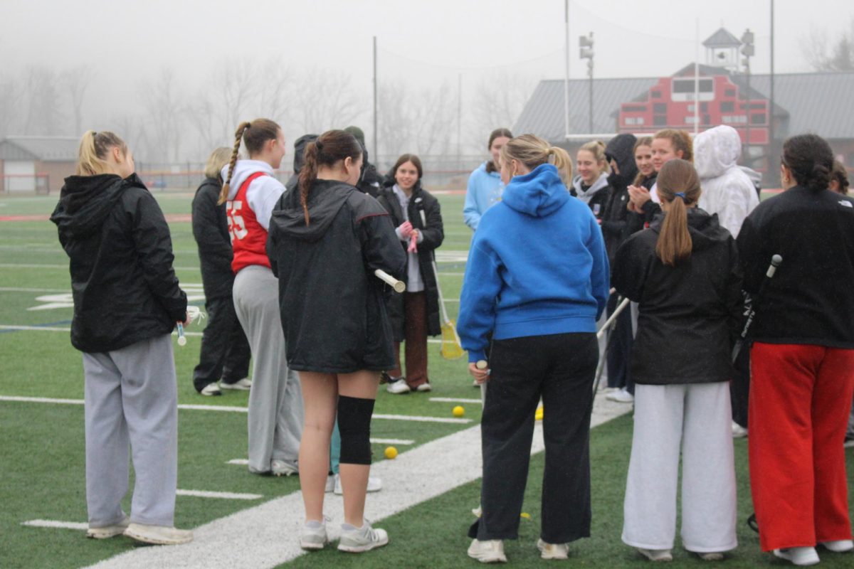  The Girls Lacrosse team talking about the plan for practice and the activities they will do.
