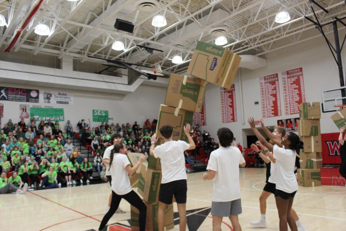 The high school student team works together during the box stacking competition.¨There was definitely some pressure because we were down by a few points. We had thought about it earlier and decided to have each person go in order of height. We mainly focused on keeping the tower balanced with our placement of the boxes.¨ Hogde said.
