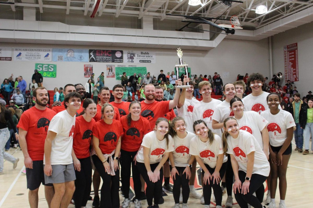 Members of the high school student team and teacher team pose together with the secondary schools division championship trophy. The two teams tied this year. 
¨I had a great time at the Battle of the Buildings,” Social Studies teacher Marcello Negrette said. “We did significantly better than last year. While we were not the sole winners, it was still great to share a victory with the student team. Overall, it was very exciting. There were games I did not expect to do well in, as well as games that I expected to do well in that did not go as expected. The student team and the middle school kept it very competitive. There wasn't a moment when I felt that there was a clear winner. The atmosphere in the gymnasium is why I decided to do it again this year and why I want to continue next year.¨
