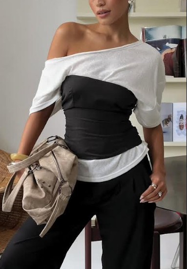 The model is wearing a white off-the-shoulder top with a black strapless shirt over it, black pants and  beige bag. Photograph Posted by @princesspolly via Instagram