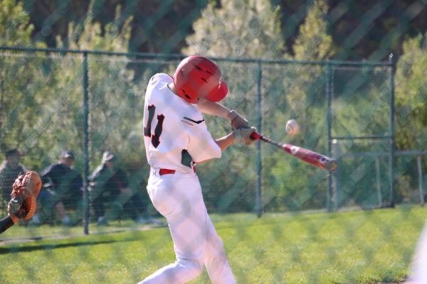 Junior Henry Heilman hits a double in the baseball team’s game against Dover on April 13. Heilman had two hits this game, and finished the season with a batting average of .310; the second best average on the team. Photograph by Tim Hare